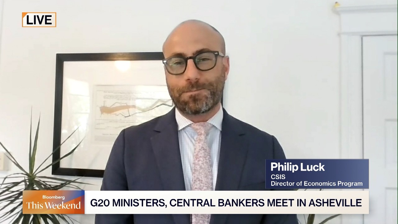 Live interview: Philip Luck, CSIS Director of Economics, in a navy suit and pink tie speaks from a home office; lower third shows his name and title with a G20 headline.
