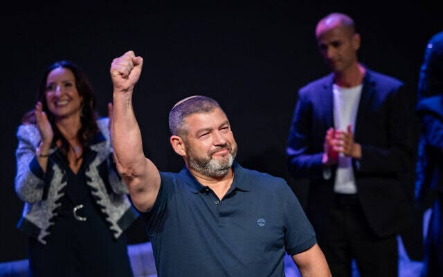 Ofer Winter raising his fist on stage at a political rally